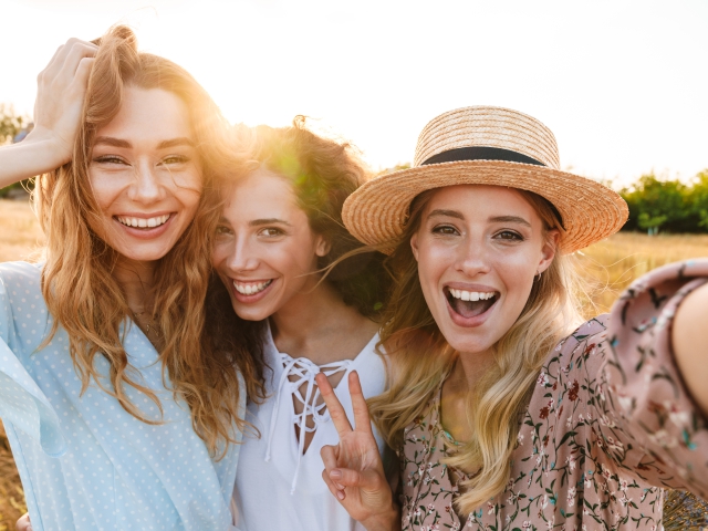 Trzy uśmiechnietę kobiety robiące sobie zdjęcie telefonem